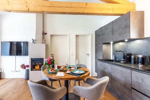 Ferienwohnung Seeheimat | Gedeckter Tisch mit Küche, Kamin & TV