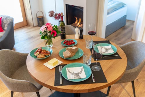 Ferienwohnung Seeheimat | Gedeckter Tisch im Wohnbereich mit Kamin