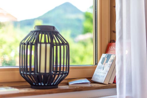 Ferienwohnung Seeheimat | Kerze & Lesematerial auf der Fensterbank